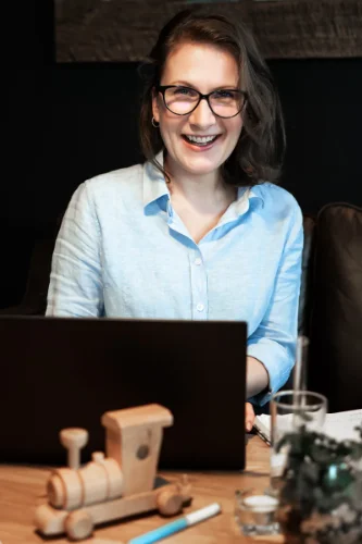 Brandová fotografie s copywriterkou píšící do poznámkového bloku perem s kávou a mašinkou na stole